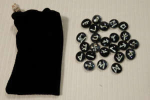 White on black Runes with black stretch-velvet pouch.
